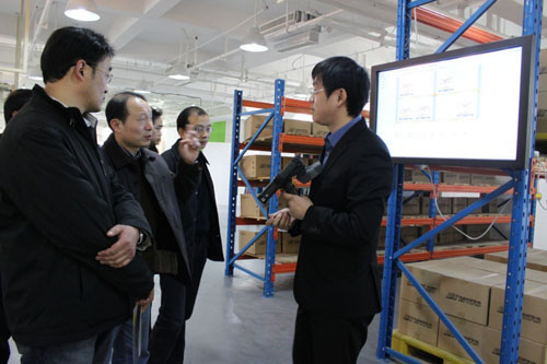 利奧創(chuàng)新科技工作人員正在向吳肇明處長等人講解RFID二維倉庫系統(tǒng)的功能特點